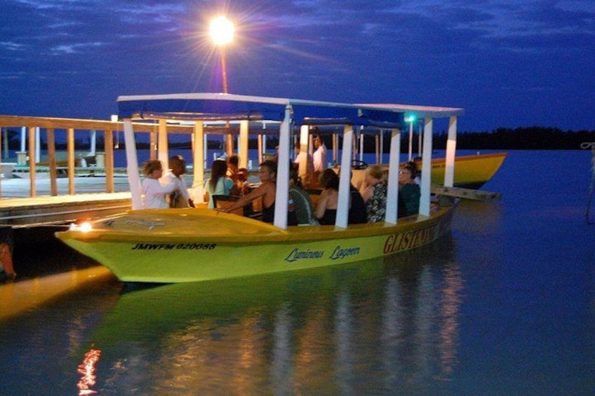 A boat with people on it, docked at a pier. 4
