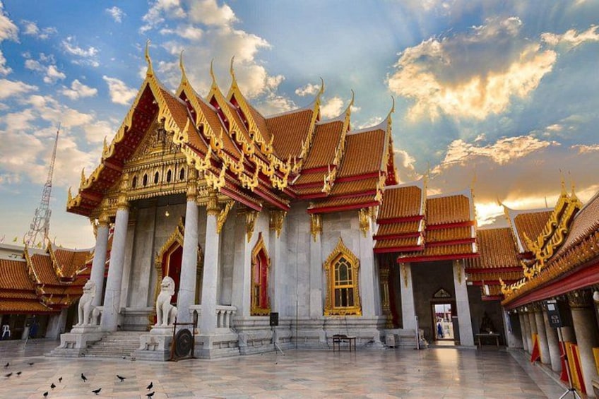 Ein traditioneller thailändischer Tempel mit aufwendigen goldenen Dächern und weißen Säulen. 4