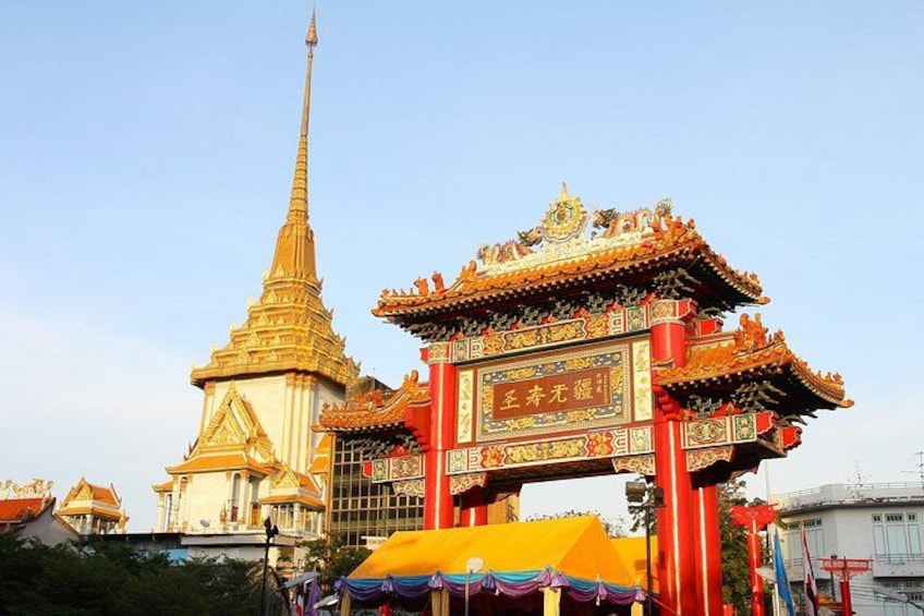 Ein traditioneller thailändischer Tempel mit goldenem Turm und einem bunten Tor. 2