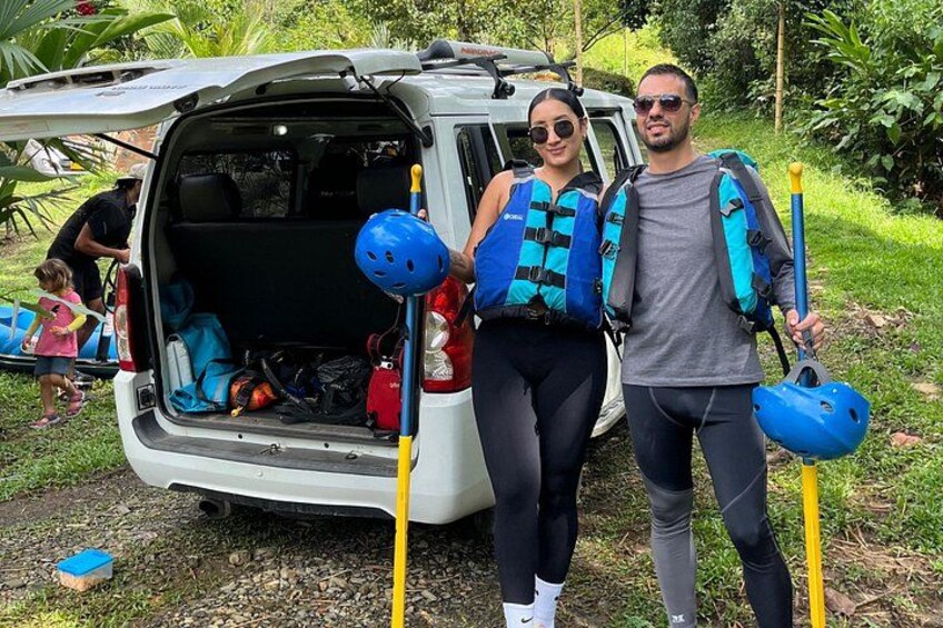 Un fourgon équipé d’un porte-bagages sur le toit, une personne tenant un casque bleu et une autre personne portant un gilet de sauvetage bleu. 2