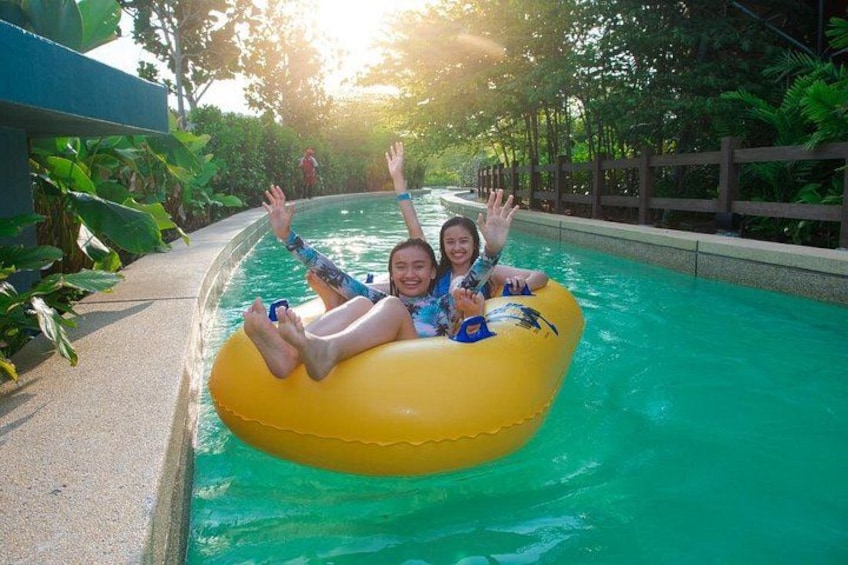 Two people on a yellow raft in a water park. 1