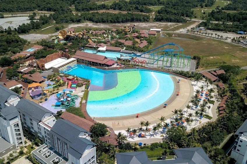 A large swimming pool with a water slide and a beach area. 4