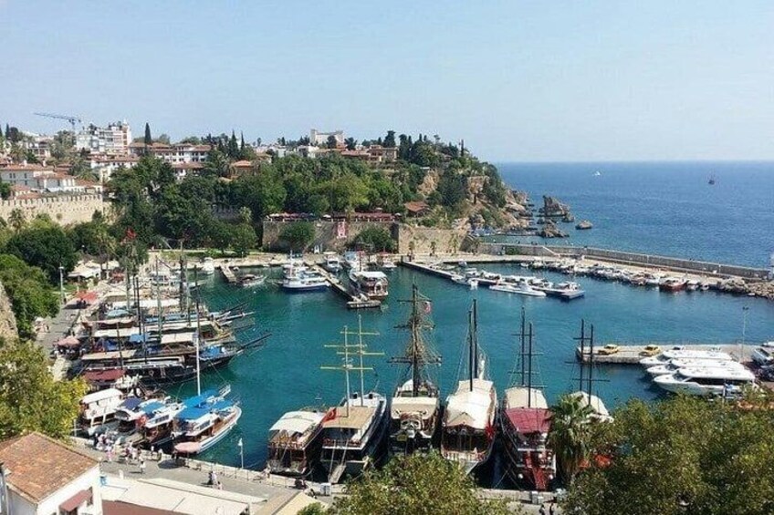 A coastal town with a marina, boats, and a hill with buildings. 3