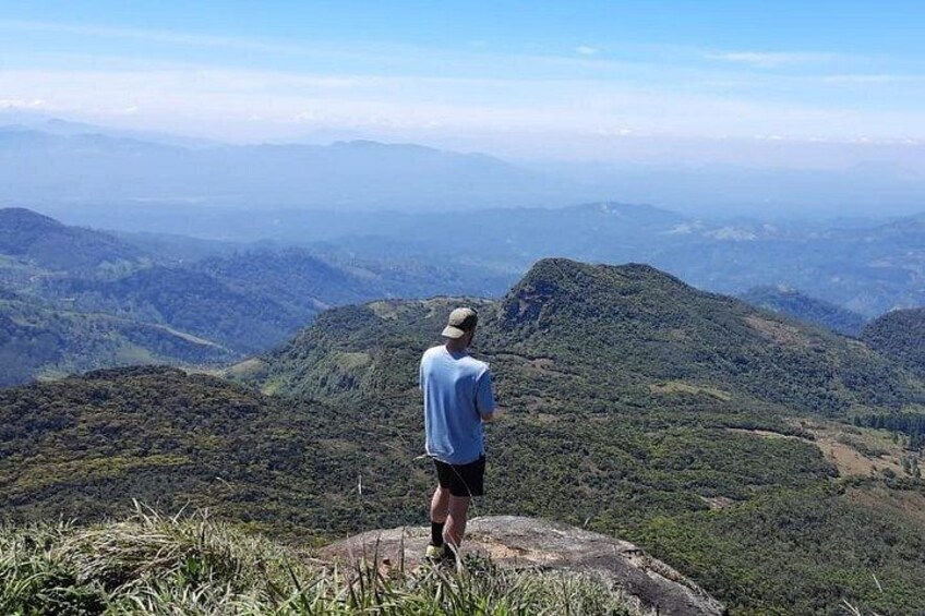 A person standing on a hill overlooking a mountainous landscape. 4