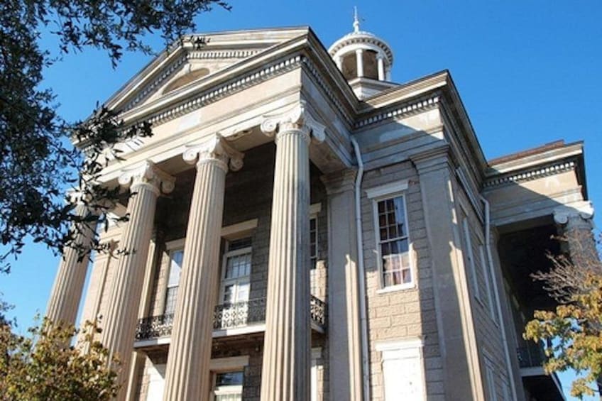 A classical building with columns, a dome, and a balcony. 3