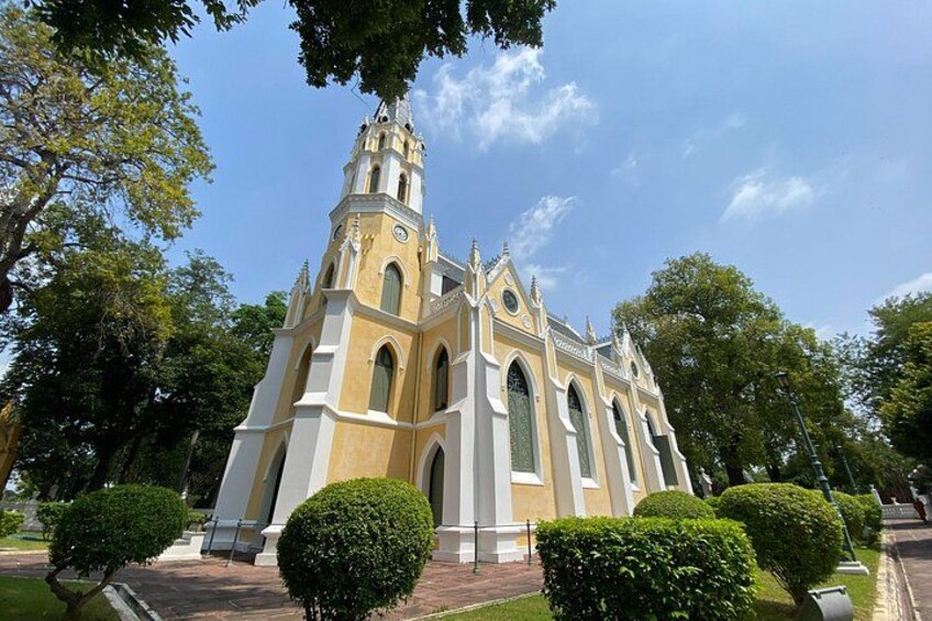 A church with a tall bell tower, surrounded by well-maintained hedges and trees. 2