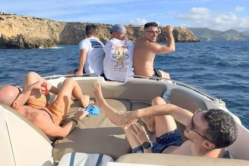 A group of people on a boat with rocky cliffs in the background. 5