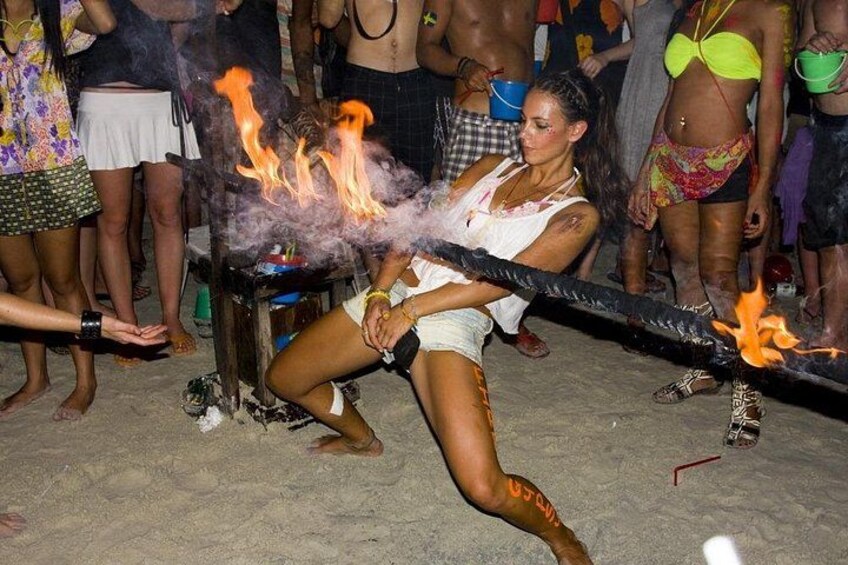 A person performing a fire act with a long stick and flames at the end. 5