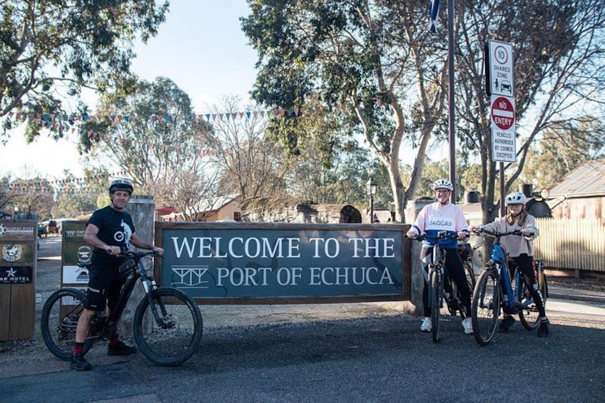 Un letrero de bienvenida al Puerto de Echuca con ciclistas. 1