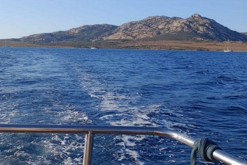 A boat on a body of water with mountains in the background. 2