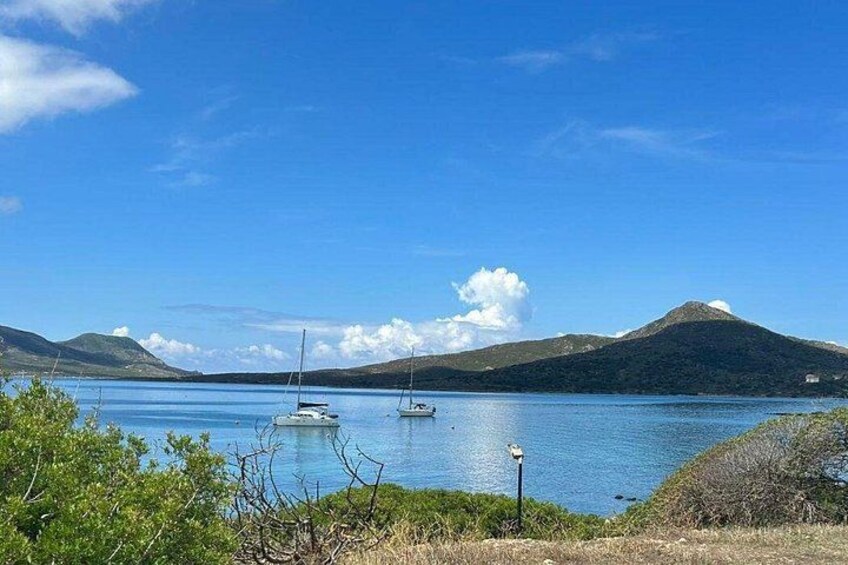 A calm lake with boats, a clear sky, and distant mountains. 3