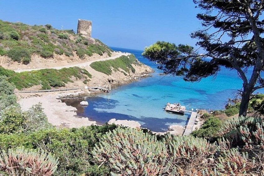 A coastal landscape with a tower, clear blue sea, and a boat. 2