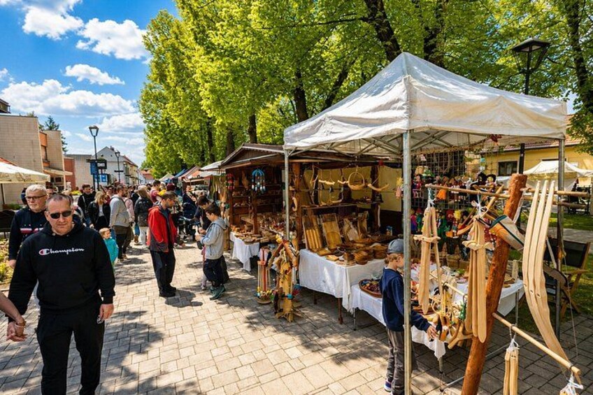 A market with wooden crafts and a white tent. 3