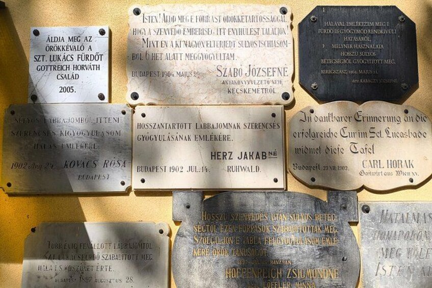 Eine Ansammlung von Gedenktafeln mit Inschriften in Ungarisch, angebracht an einer Wand. 3