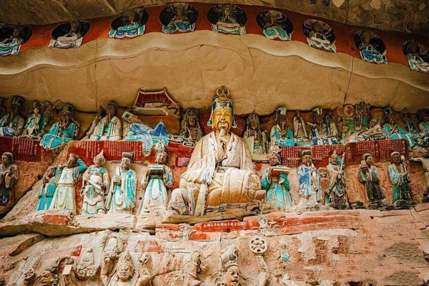 Een groot Boeddhabeeld omringd door kleinere beeldjes in een tempel. 3