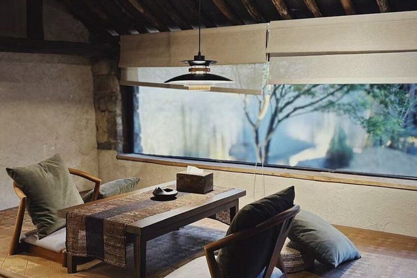 Ein rustikales Interieur mit einem Holztisch, Stühlen und einem großen Fenster. 3