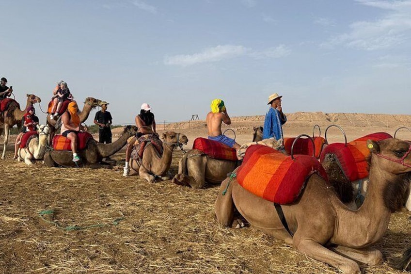 Un grupo de camellos con jinetes en un paisaje desértico. 2