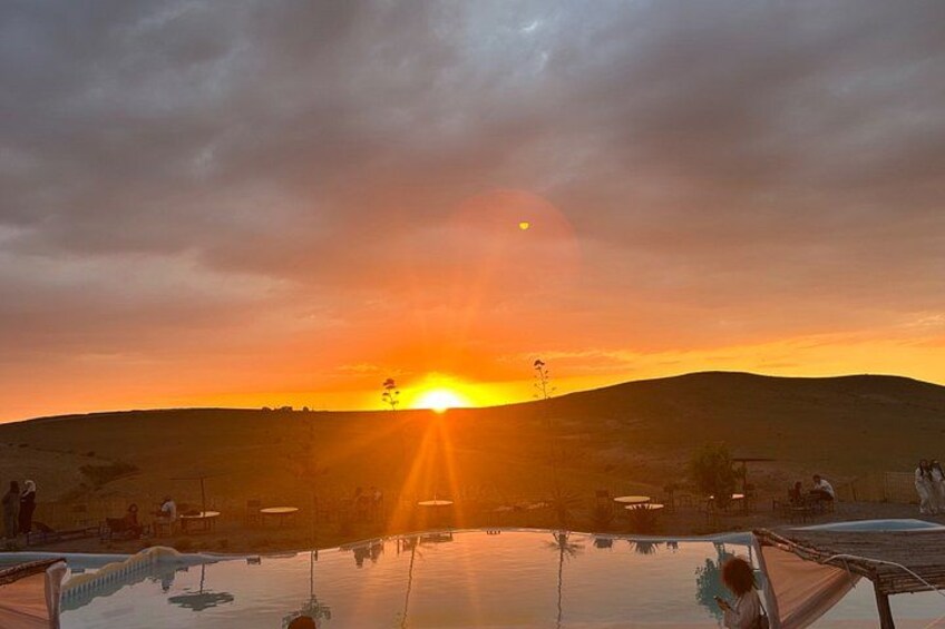 A sunset over a body of water with a hill in the background. 3