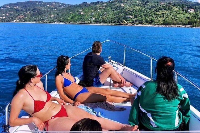 Eine Gruppe von Menschen auf einem Boot auf dem Wasser, im Hintergrund eine Küstenlinie. 5
