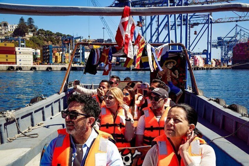 A boat with people wearing life jackets, a dock, and a crane in the background. 4