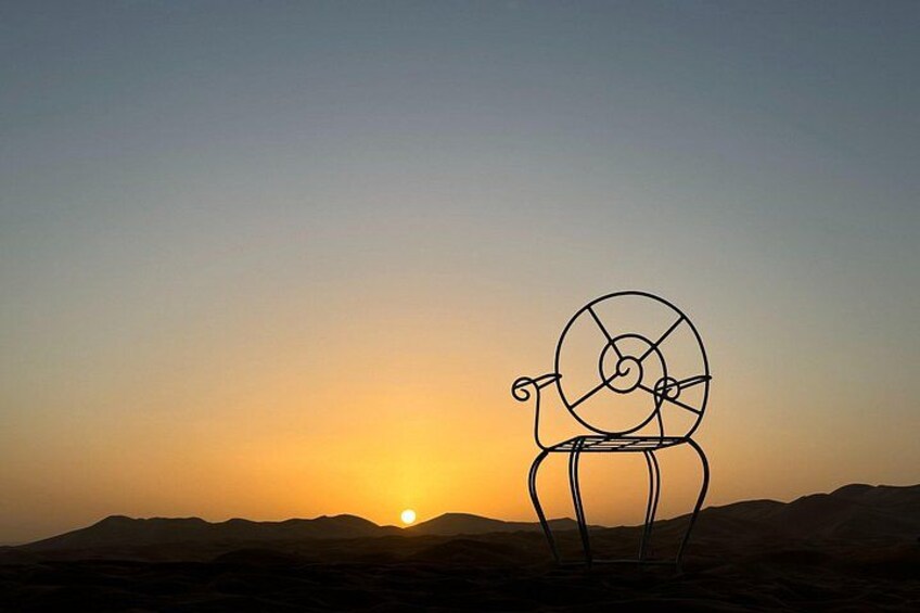 A desert landscape at sunset with a wireframe sculpture of a snail. 4