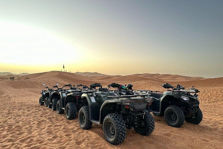 A row of ATVs parked on a desert dune. 5