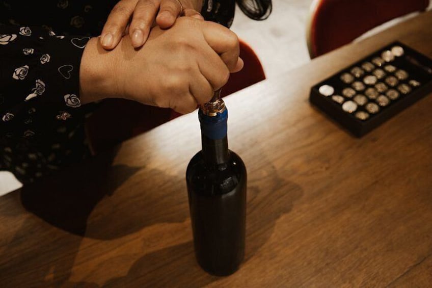 Une personne qui ouvre une bouteille de vin. 4