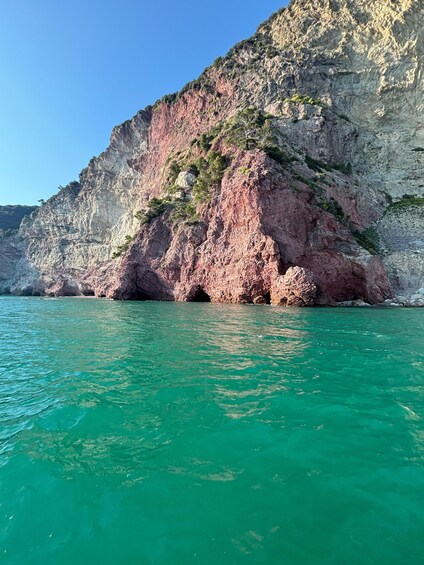 A coastal cliff with turquoise water. 2