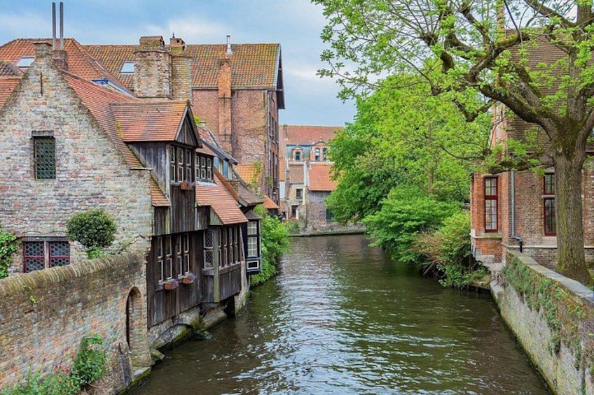 A narrow waterway flanked by historic buildings with timber framing and brick facades. 3