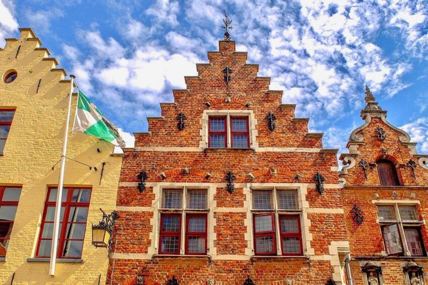 A historic building with a steeply pitched roof, red brick facade, and ornate detailing. 2