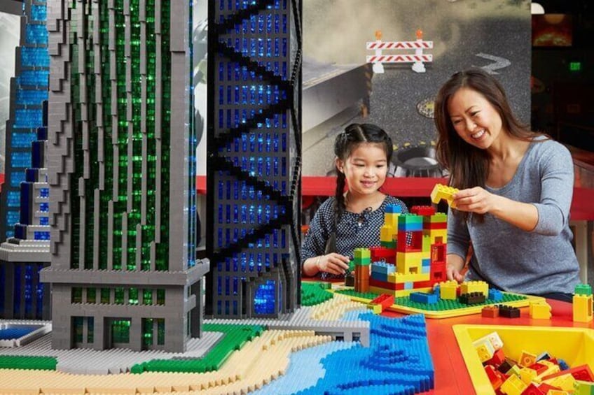 Een LEGO stadsbeeld met een hoog gebouw en een rivier. 1