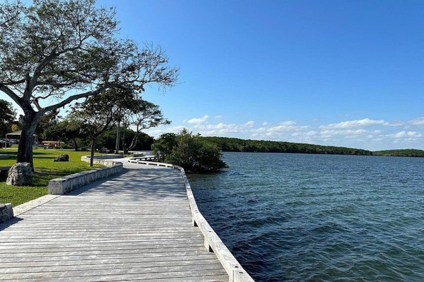 A wooden pier extending into a calm lake, surrounded by trees and grassy areas. 2