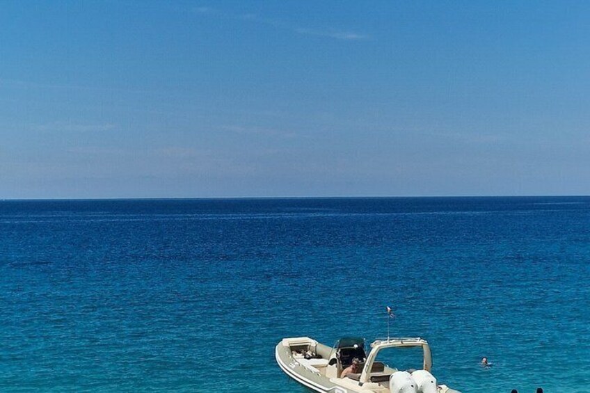 A boat on calm blue water with a clear sky. 2