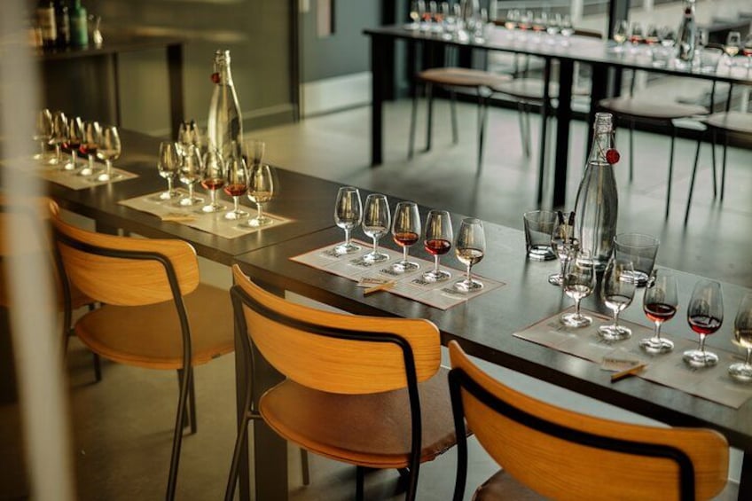 En restaurant med borde dækket til vinsmagning, med vinglas og flasker. 4