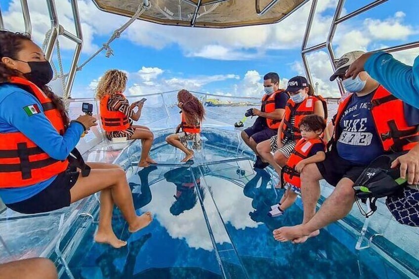 Personas en un bote con chalecos salvavidas, cielo despejado y agua tranquila. 1