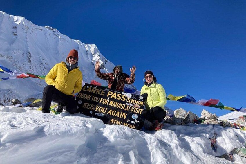 A group of people on a snowy mountain with a sign that reads 'LARKE PASS THANK YOU FOR MANAS SEE YOU AGAIN'. 5