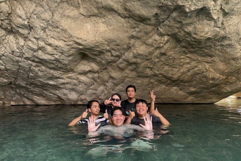 Un grupo de personas en una piscina natural con paredes rocosas. 4