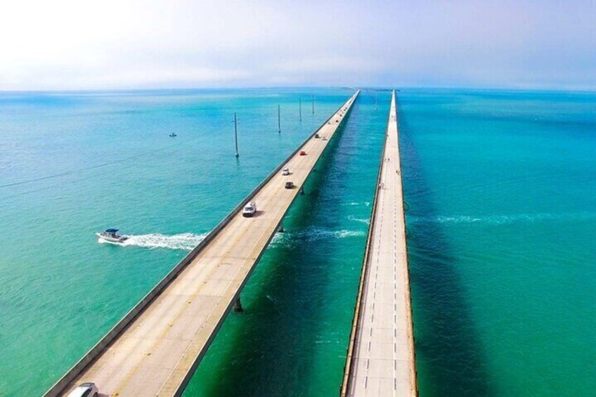 Un long pont enjambant des eaux turquoise, sur lequel circulent des véhicules. 3