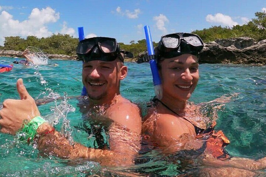 Two people snorkeling in clear blue water with snorkels. 5