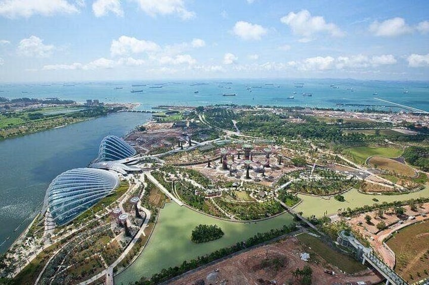 A coastal cityscape with modern architecture, a river, and a park with a circular layout. 2