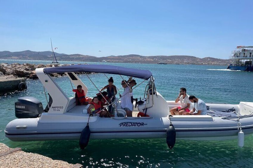 A small motorboat named 'Predator' docked at a pier with people on board. 1