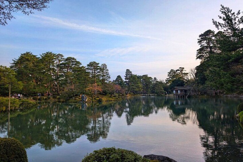 Un lago tranquilo rodeado de árboles y una casa pequeña. 3