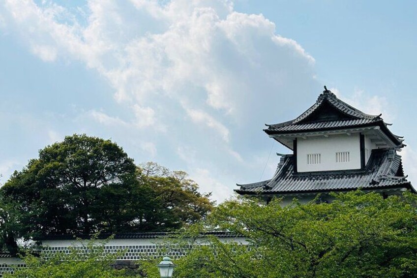 Un castillo japonés tradicional con un techo de varios niveles, rodeado de abundante vegetación y un cielo despejado. 4