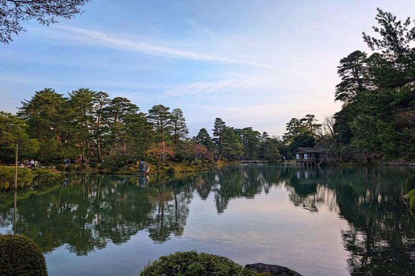 Un lago tranquilo rodeado de árboles y una pequeña casa. 2