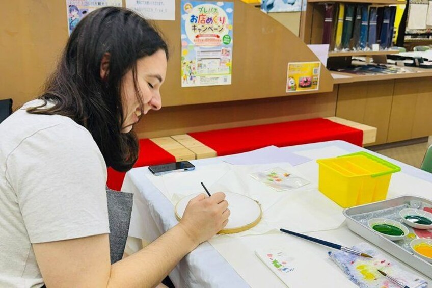 Una persona pintando en una mesa con materiales de arte. 5
