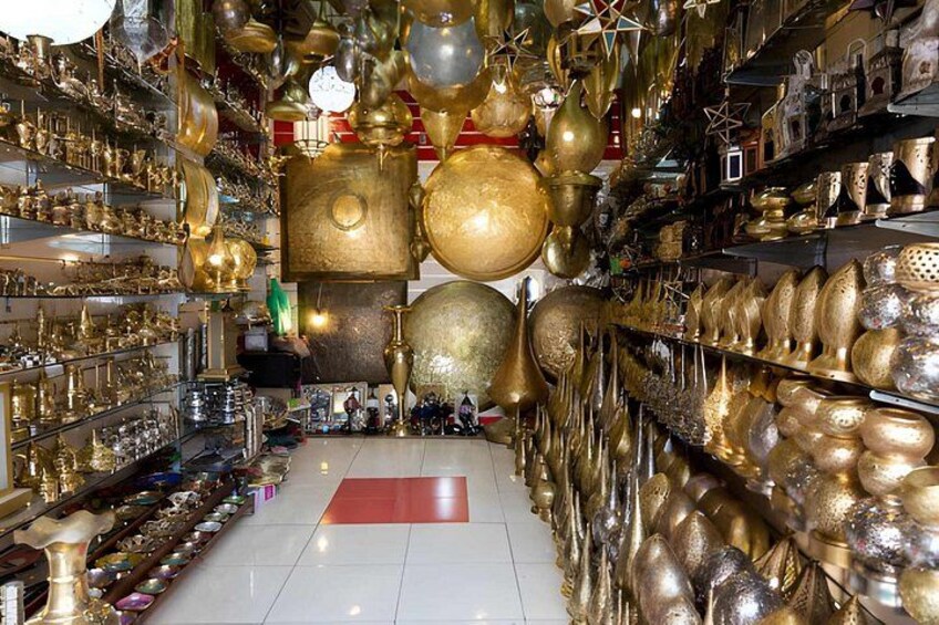 A store with shelves filled with brass and gold-colored items. 1