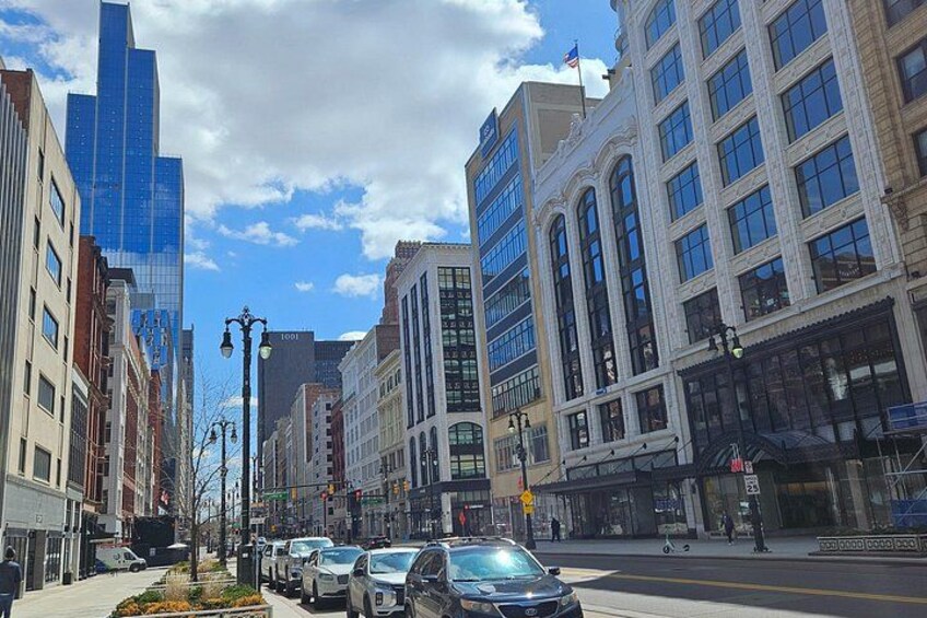 A city street with tall buildings, cars, and a clear sky. 4