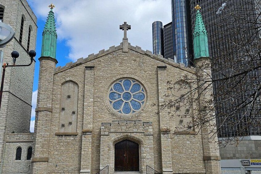 A church with a large circular stained glass window, a cross on top, and two spires. 2