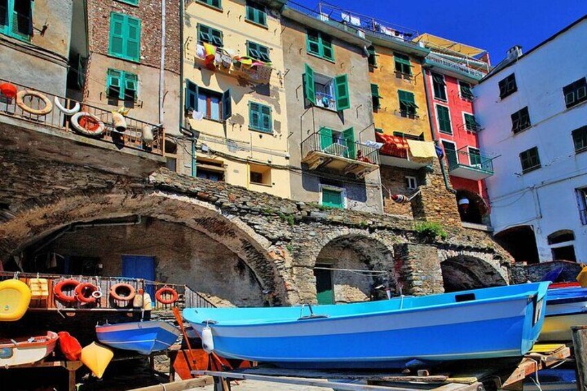 Colorful buildings, a stone archway, and boats. 2