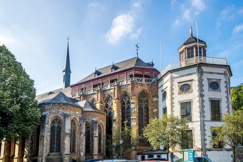 A historic church with a spire, a red-roofed pavilion, and a clock tower. 2